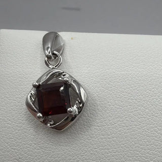 Sterling silver garnet pendant, square-cut garnet in twisted open frame