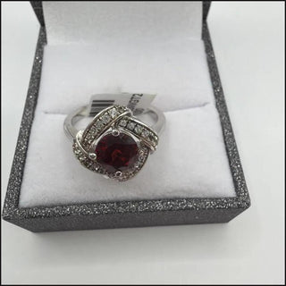 Sterling silver round garnet ring in a swirl of white topaz